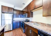 Thumbnail 2 of 21 - kitchen with island, stainless steel appliances and hardwood flooring at archer park apartments in southeast Washington dc